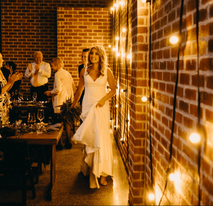 festoon lighting on rustic wall for wedding