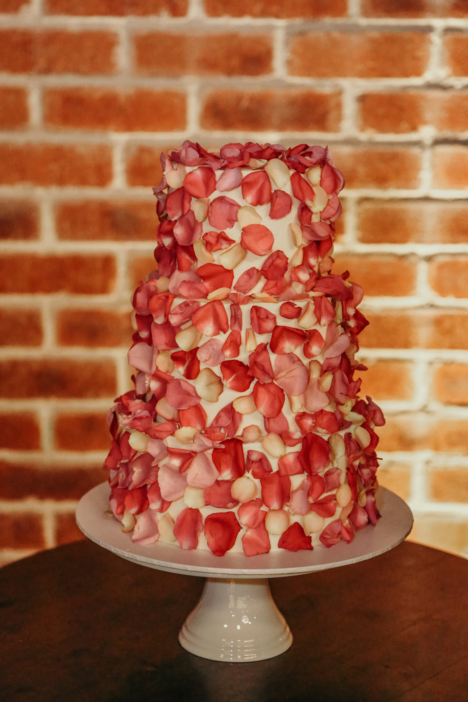 Three-tier engagement party cake covered in rose petals at Factory 51 in Brisbane.