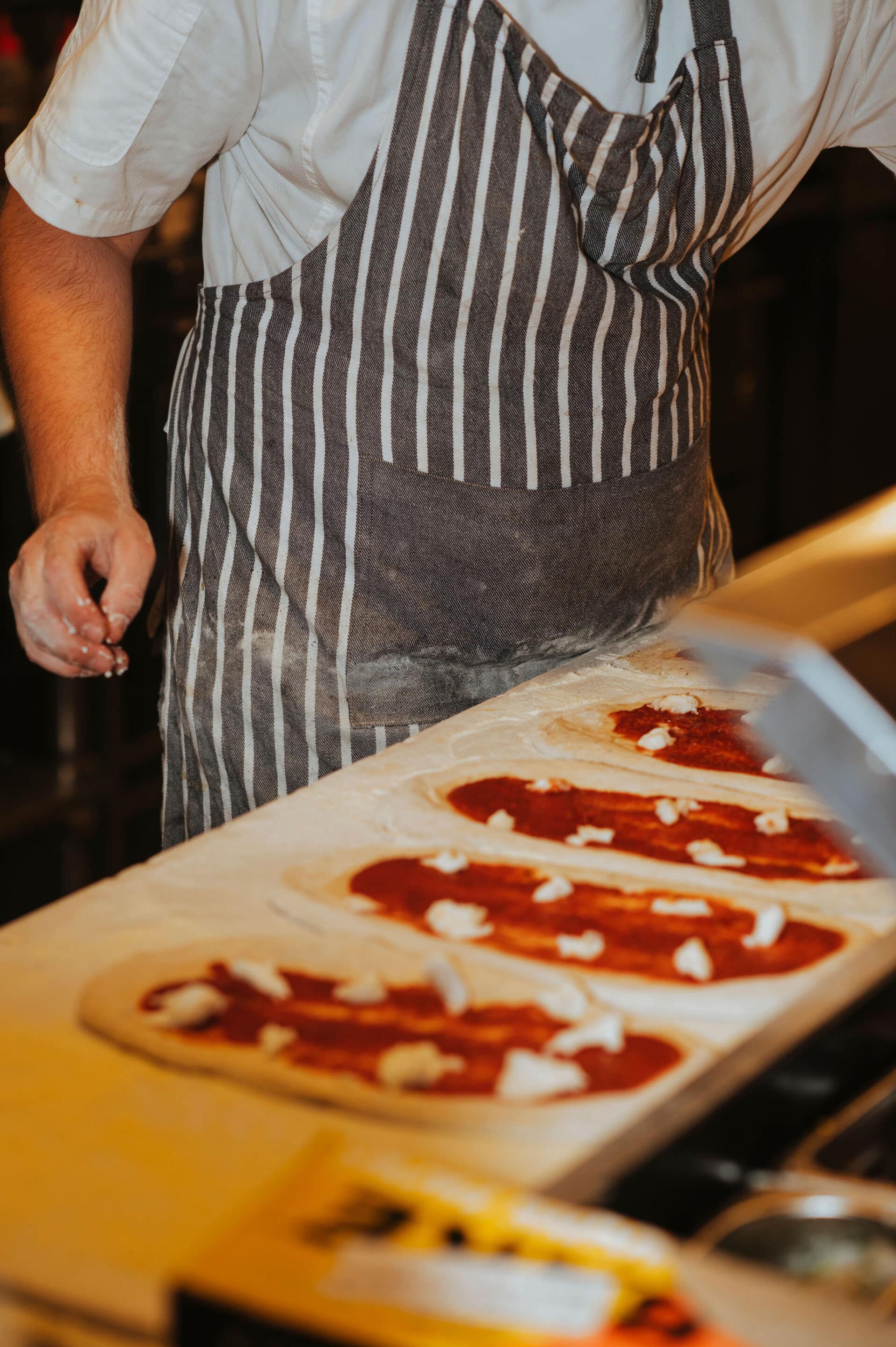 Chef preparing antipasti in the kitchen at Factory51 Coorparoo, with ingredients arranged near the woodfire oven