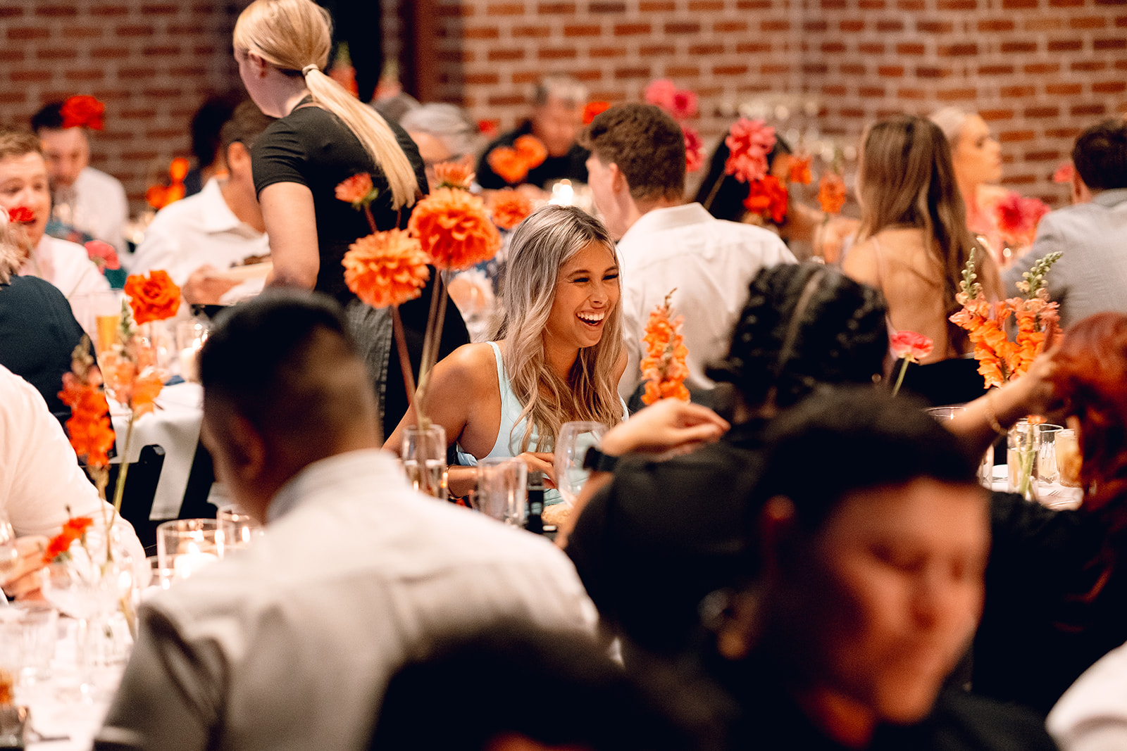 Guests laughing over long tables at Factory51 wedding venue