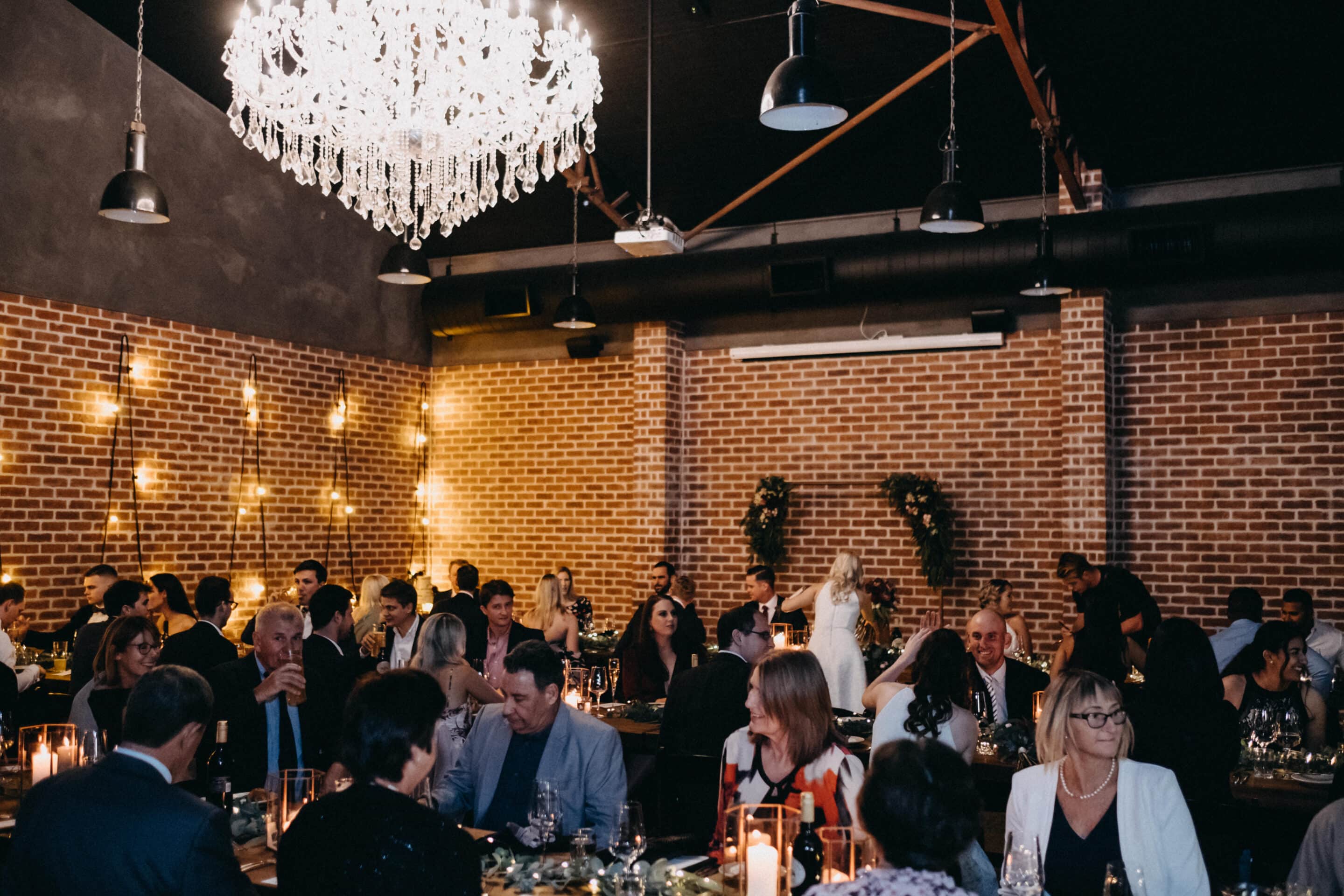 Brisbane Function Venue with Chandelier and Full Event Setup guests dining under chandelier at Brisbane function venue with exposed brick interior