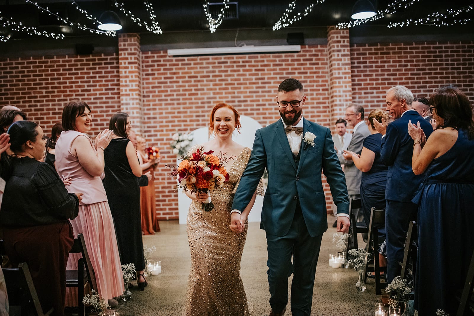 A smiling bride and groom walking back up the aisle after getting married at Factory51 Brisbane wedding venue.